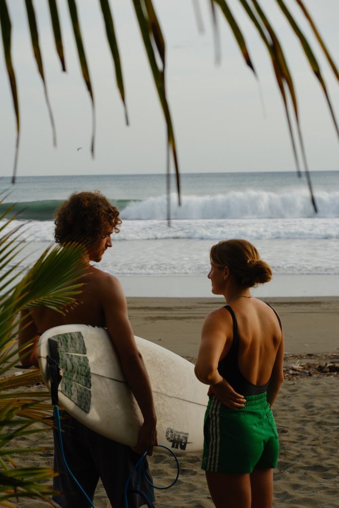 Ben and Alena looking out at the surf beneath the palms