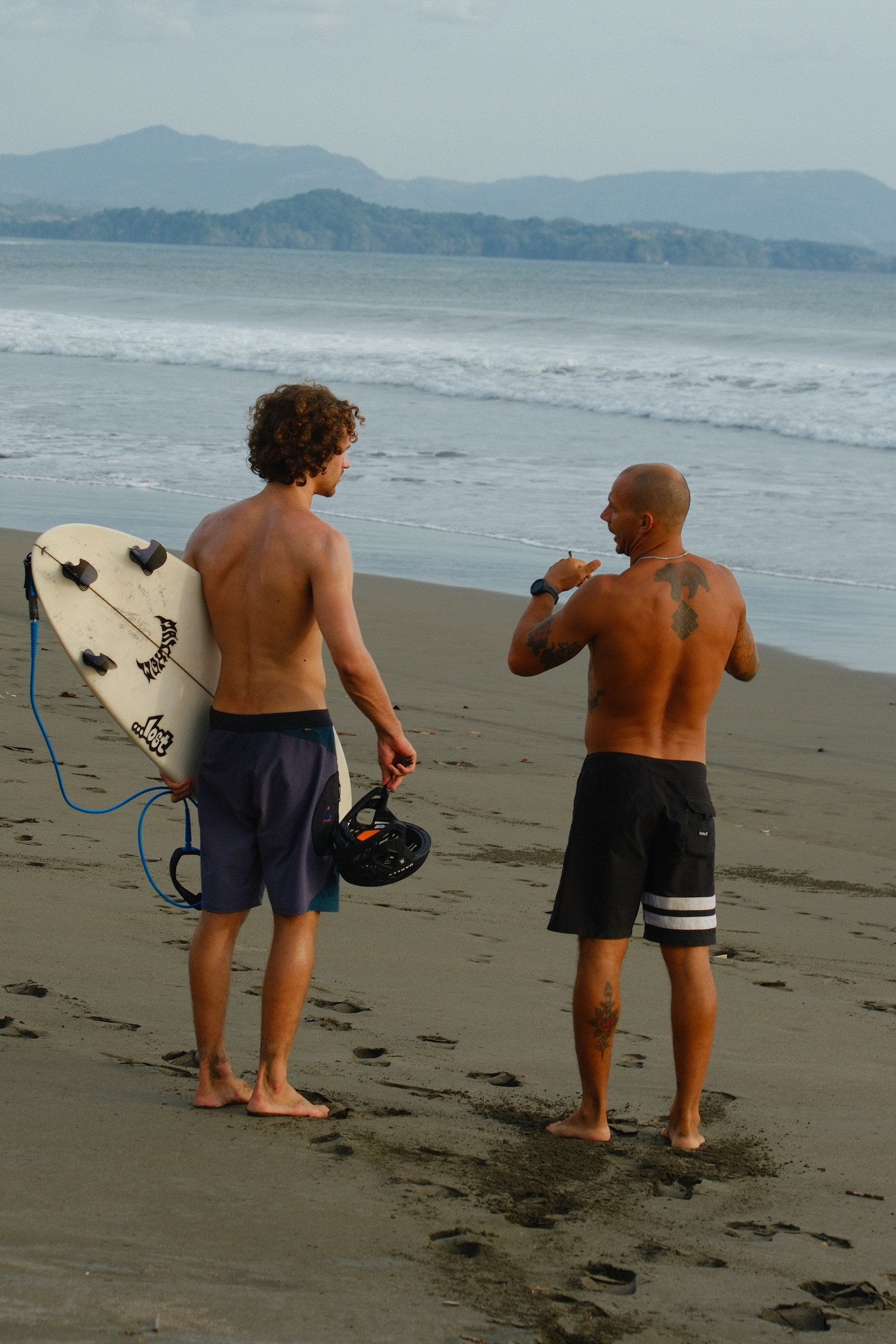 Ben talking with a local surfer beside the ocean
