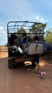 Board bags being loaded into a pickup on the road to Morrillo