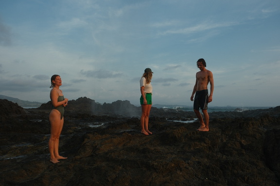 Friends exploring the dark rocks along the Morrillo coast