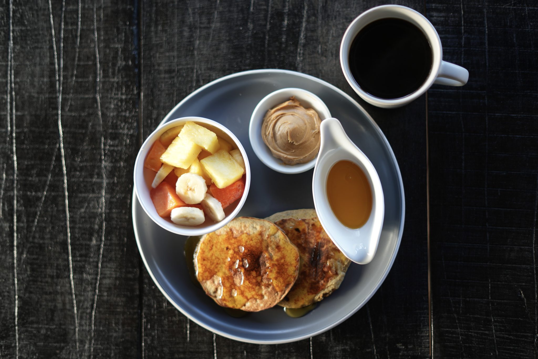Pancakes with fresh fruit, peanut butter, syrup, and coffee at Casa Morrillo